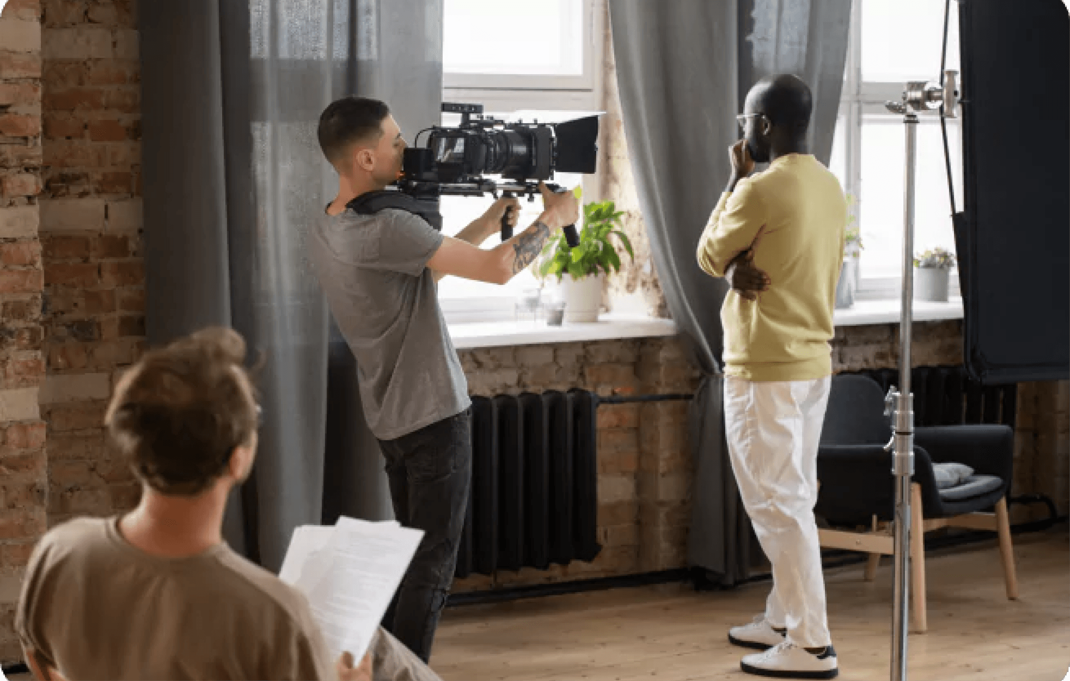 man looking out the window with camera pointing at him